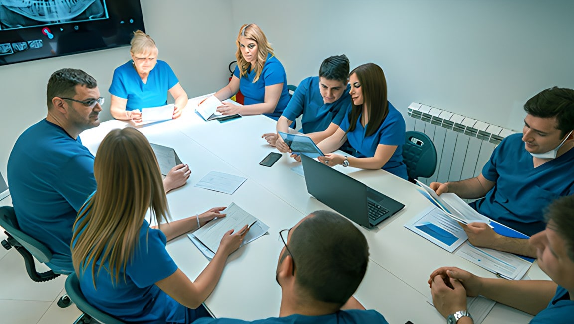 A team of dentists discussing charts and procedures