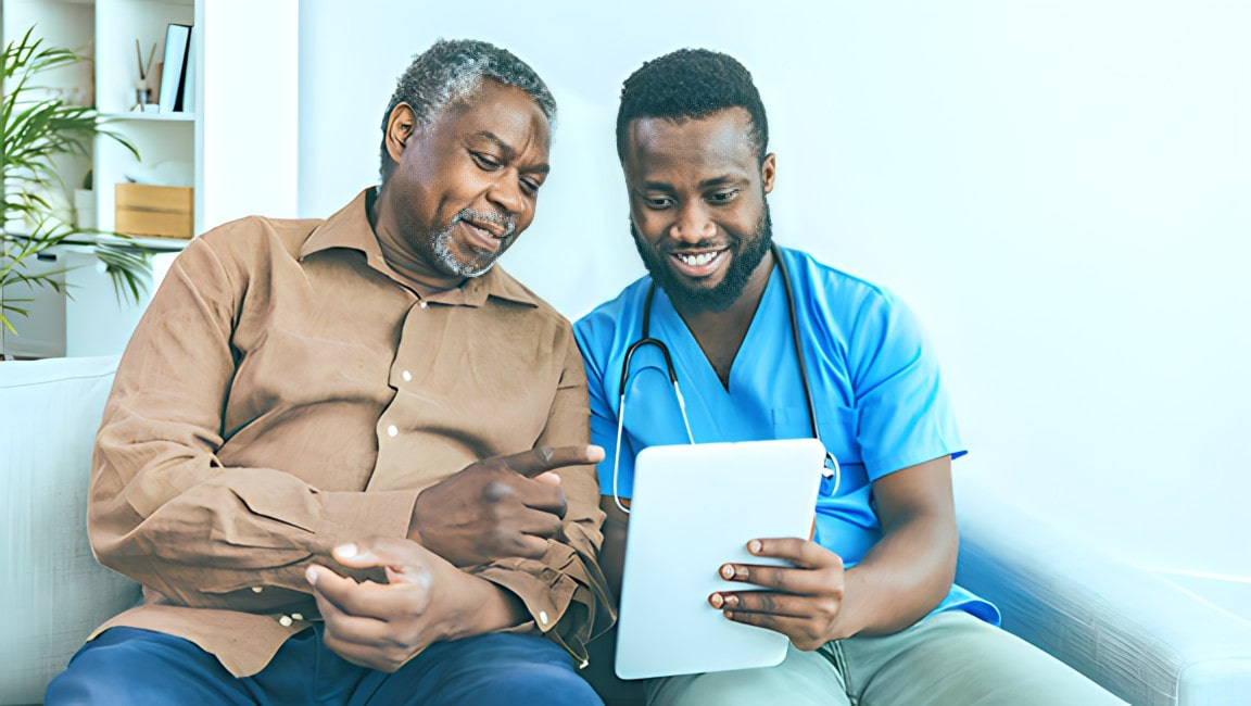 A young medical professional helping a senior patient find the right dentist for them.