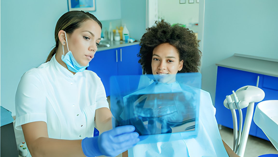 A female dentist carefully explains an x-ray to her patient.